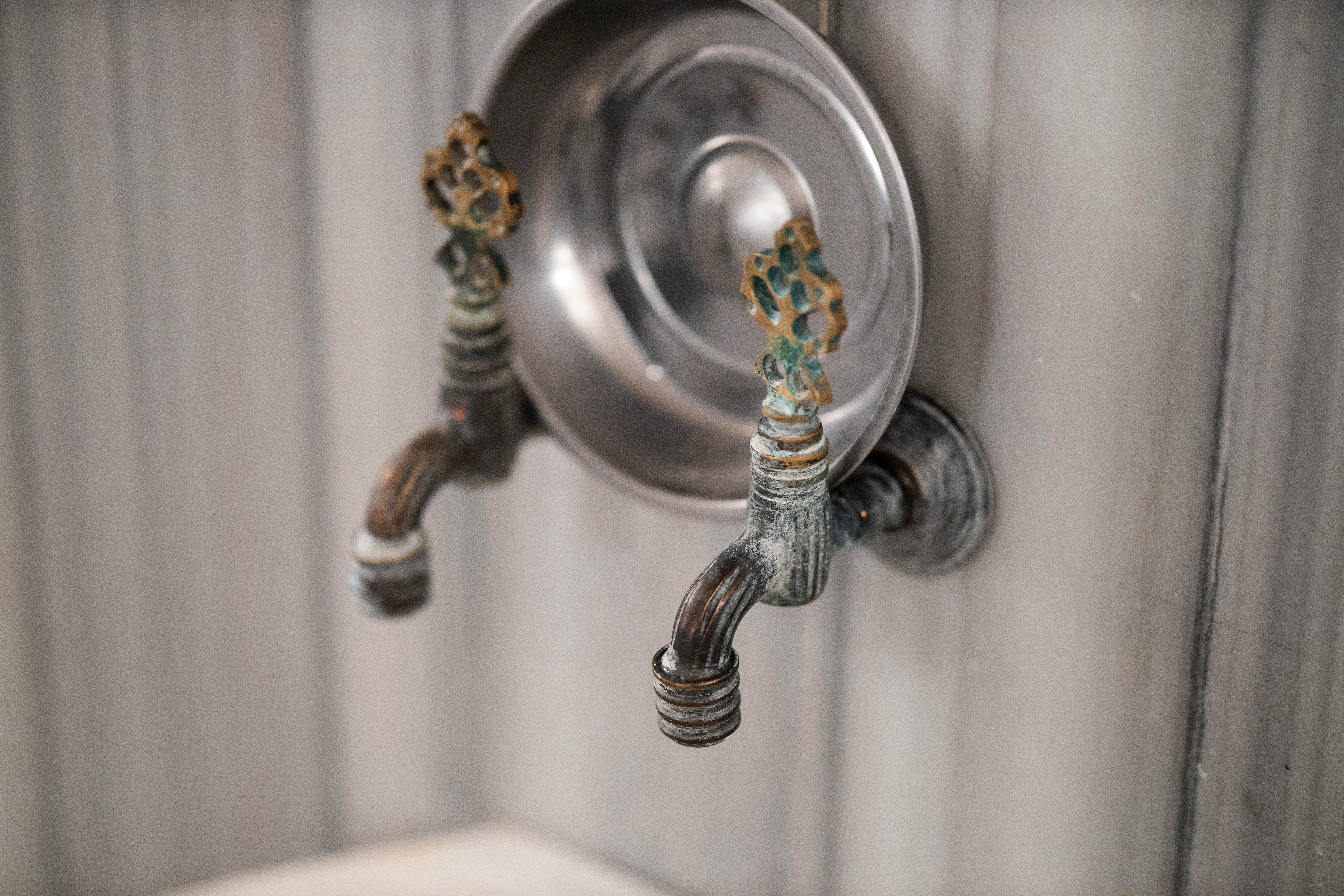 stainless steel faucet on white ceramic sink